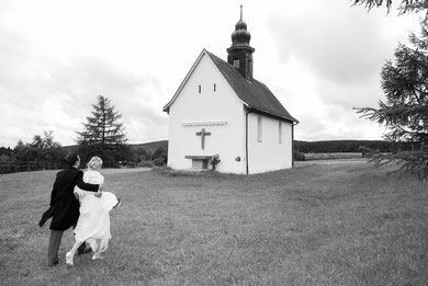 Brautpaar auf dem Weg zu kleiner Kapelle auf einem Hügel