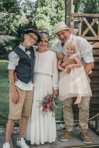 Glückliches Brautpaar mit Kindern am Hochzeitstag