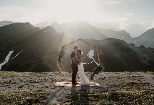 Brautpaar auf Bergspitze bei Sonnenuntergang