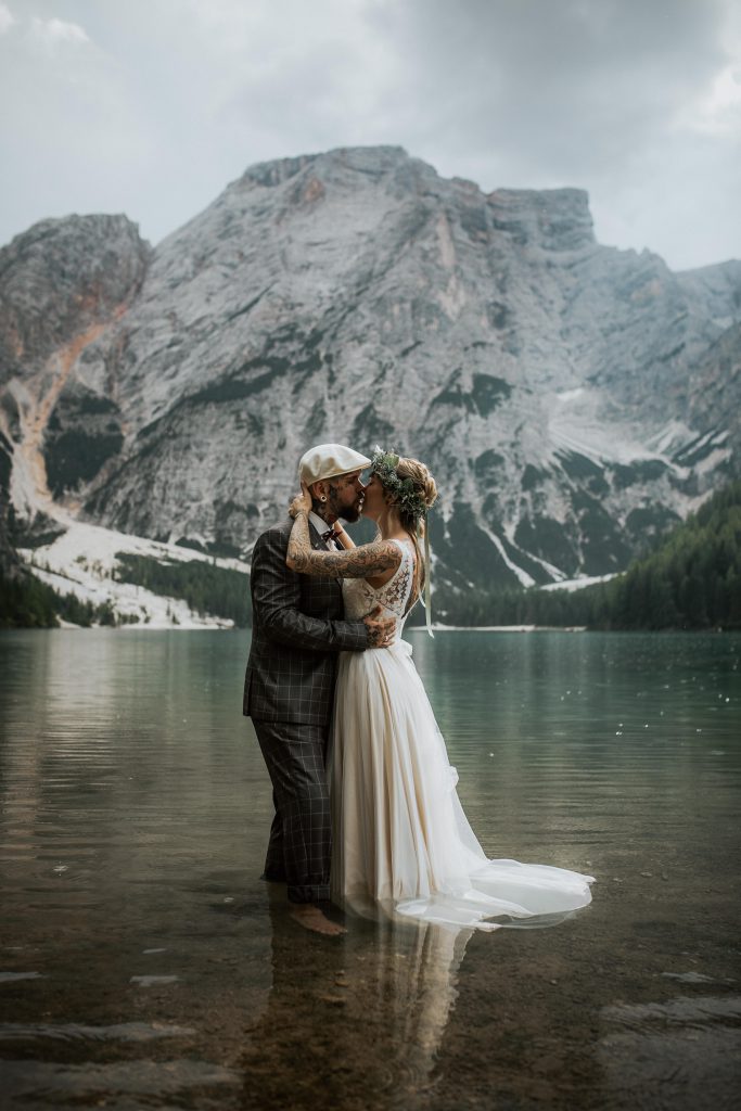 Brautpaar küsst sich mitten in einem einsamen Gebirgssee