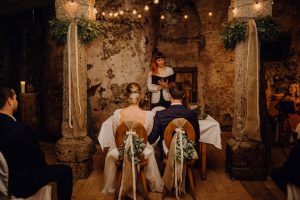 Hochzeitsrednerin Veronika mit einem Brautpaar in einem Kellergewölbe