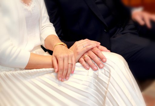 Die Hände eines Hochzeitspaares auf dem Standesamt