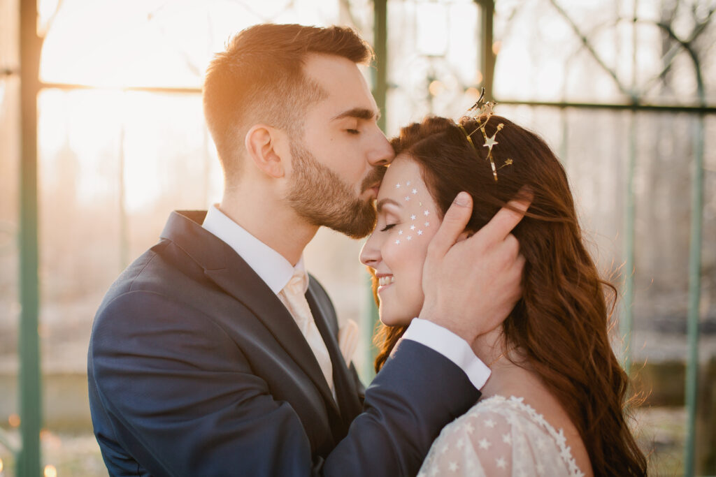 Bräutigam küsst seine Braut zärtlich auf die Stirn
