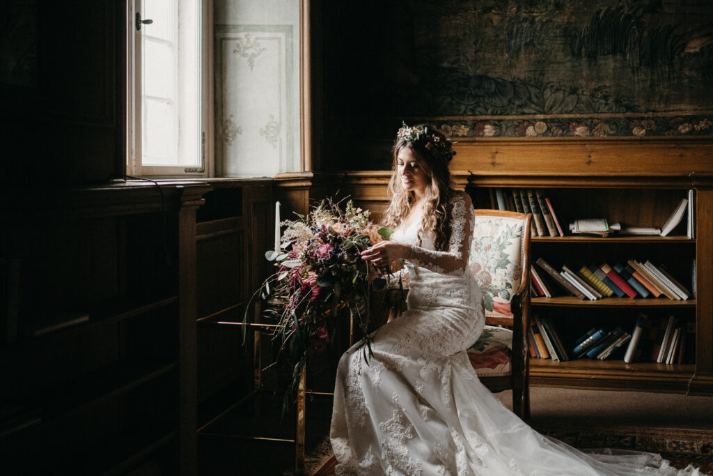 Boho Braut in moderner Spitze und wildem Blumenstrauß