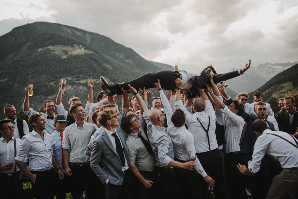 Bräutigam von Trauzeugen und Freunden auf Händen getragen | Freie Trauung | Strauß & Fliege
