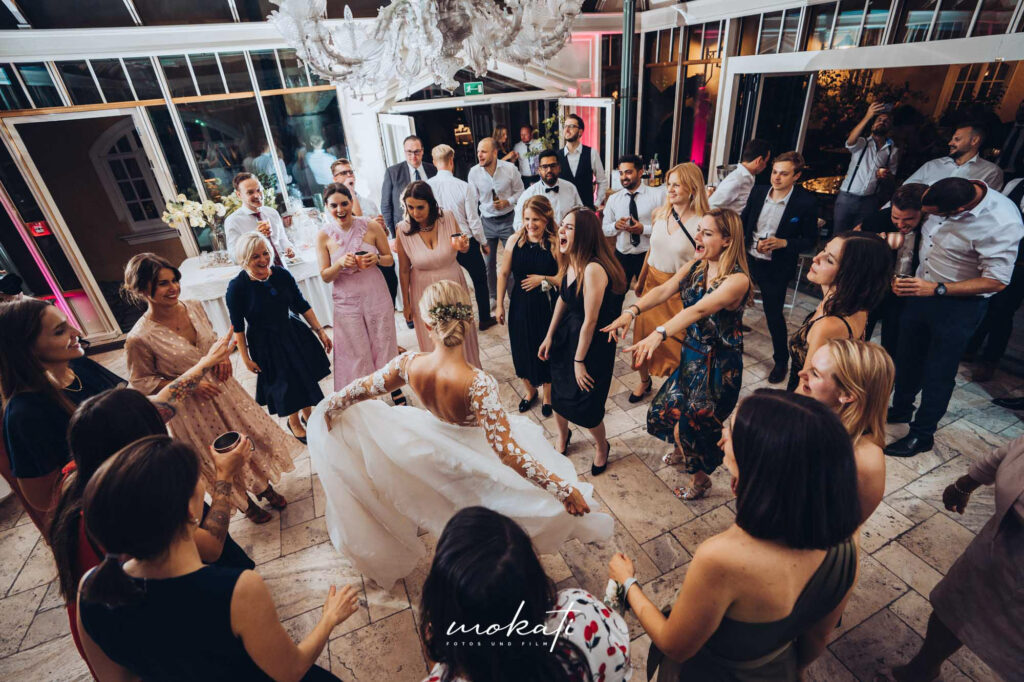 Braut tanzt ausgelassen im Kreise ihrer Freundinnen | Strauß & Fliege
